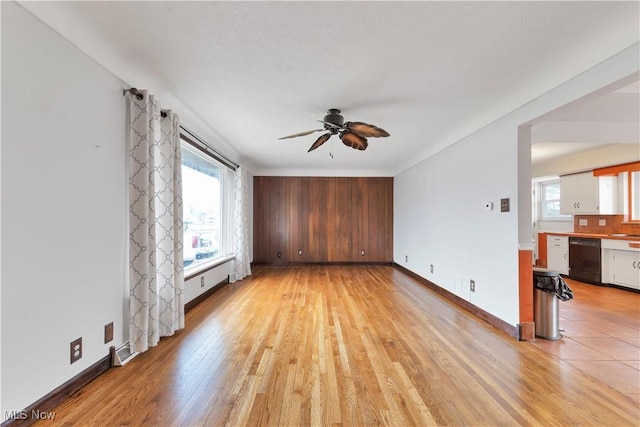 unfurnished living room featuring ceiling fan, light hardwood / wood-style floors, and baseboard heating