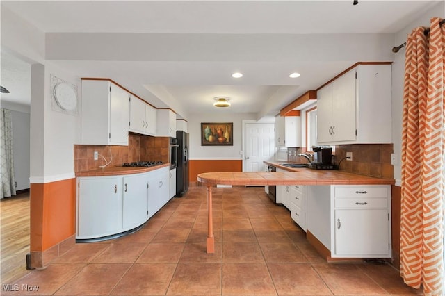 kitchen with white cabinetry, sink, and tasteful backsplash