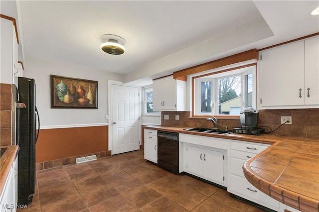 kitchen with white cabinetry, sink, black appliances, and tile counters