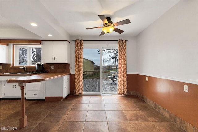 kitchen featuring tile counters, ceiling fan, white cabinetry, and sink