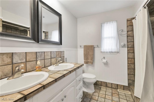 bathroom featuring decorative backsplash, vanity, and toilet