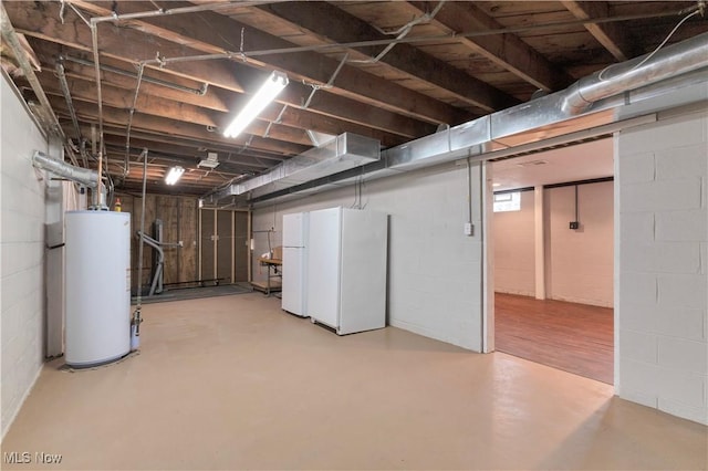 basement featuring white refrigerator and water heater