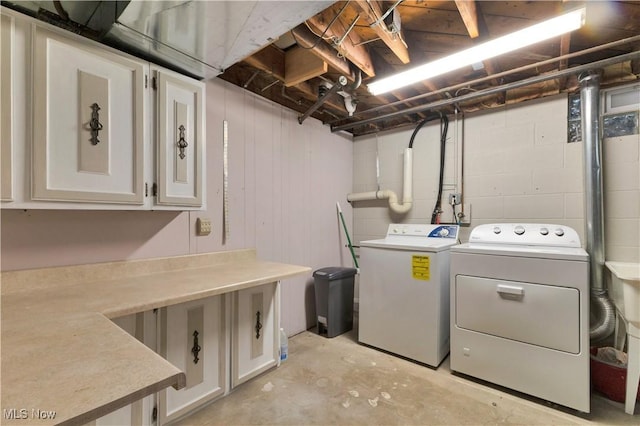 washroom featuring cabinets and washer and clothes dryer