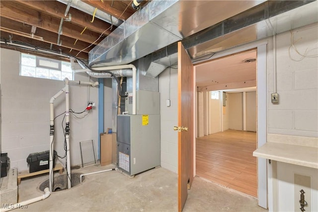 basement with light wood-type flooring and heating unit