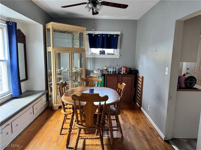 dining space featuring baseboards, a ceiling fan, and light wood finished floors