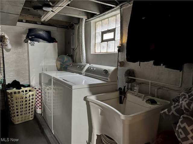 washroom featuring a sink, laundry area, and washer and clothes dryer