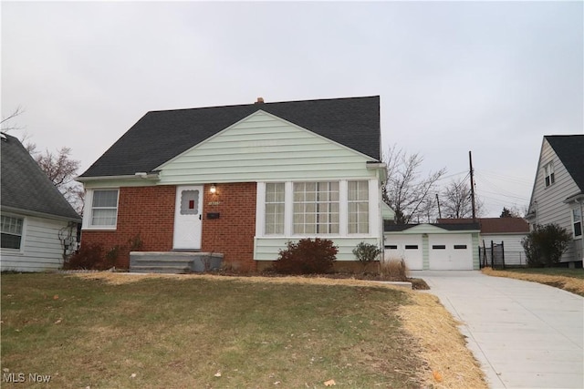 view of front of home with an outbuilding, a garage, and a front lawn