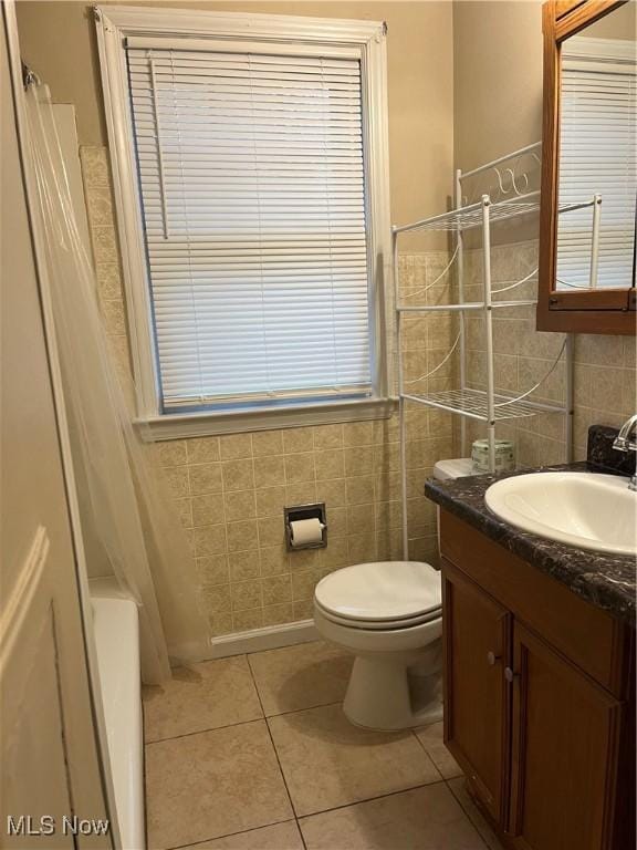 full bathroom with tile patterned flooring, vanity, tile walls, and toilet