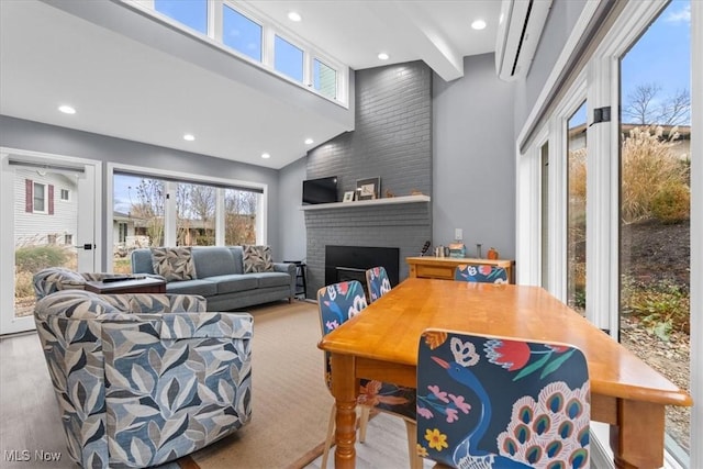 dining room with a fireplace, light wood-type flooring, and lofted ceiling