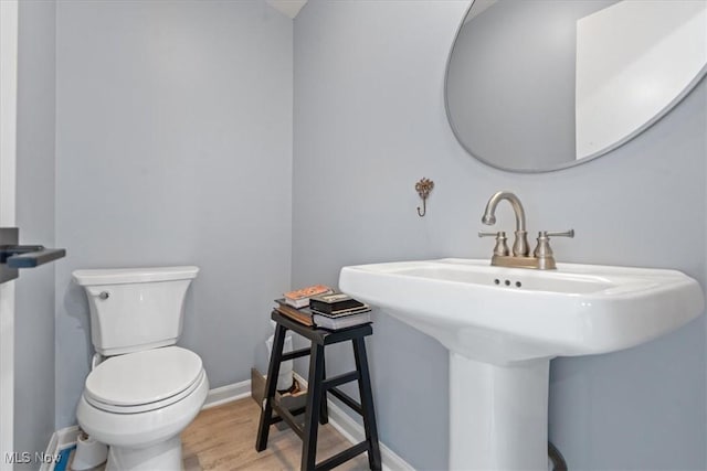 bathroom featuring hardwood / wood-style flooring, toilet, and sink