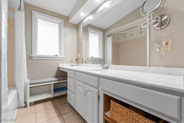 bathroom featuring vanity, tile patterned floors, plenty of natural light, and lofted ceiling