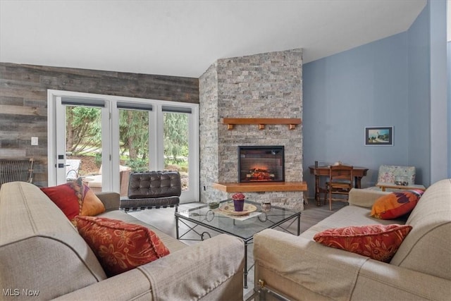 living room featuring a stone fireplace and hardwood / wood-style flooring