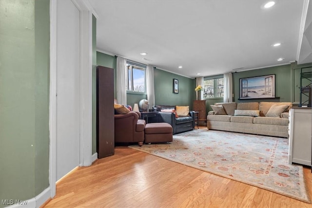 living room with crown molding and light hardwood / wood-style floors