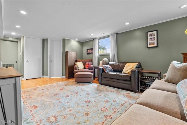 living room with light wood-type flooring and crown molding