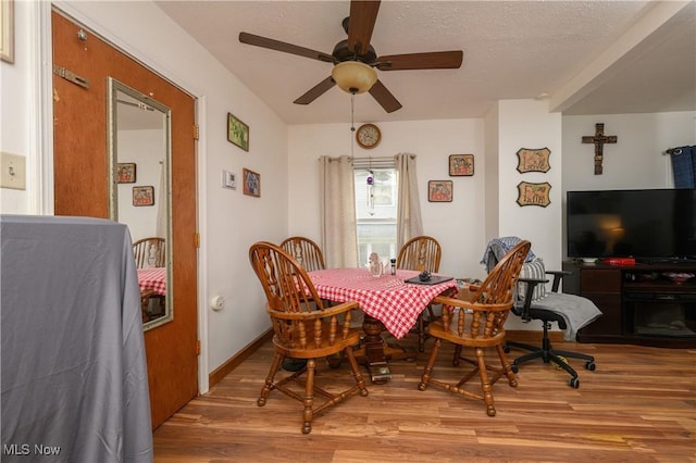 dining area featuring ceiling fan, hardwood / wood-style floors, and a textured ceiling