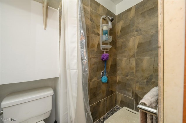 bathroom with curtained shower and toilet