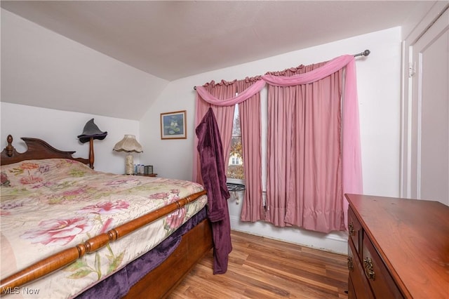 bedroom featuring wood-type flooring and vaulted ceiling