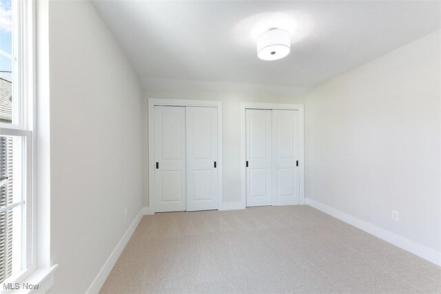 583 Iris Pl, Aurora, OH 44202 - unfurnished bedroom featuring multiple closets and light colored carpet