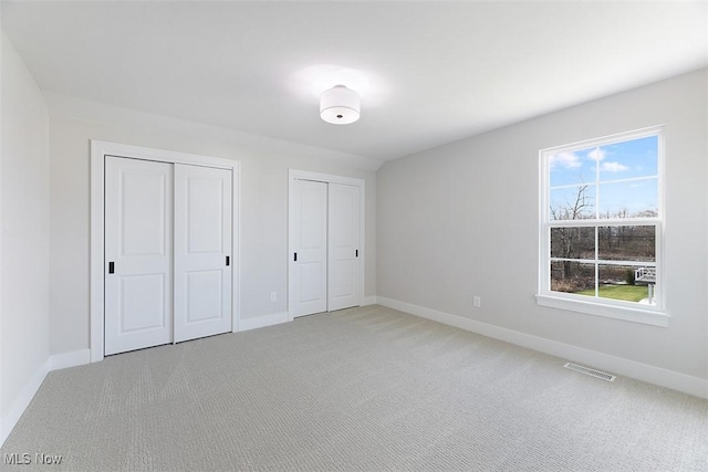 583 Iris Pl, Aurora, OH 44202 - unfurnished bedroom featuring two closets and light carpet