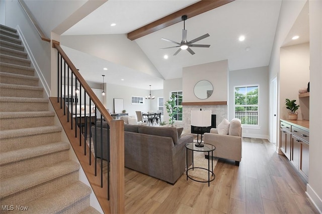 583 Iris Pl, Aurora, OH 44202 - living room featuring stairway, beam ceiling, light wood-style flooring, ceiling fan, and high vaulted ceiling
