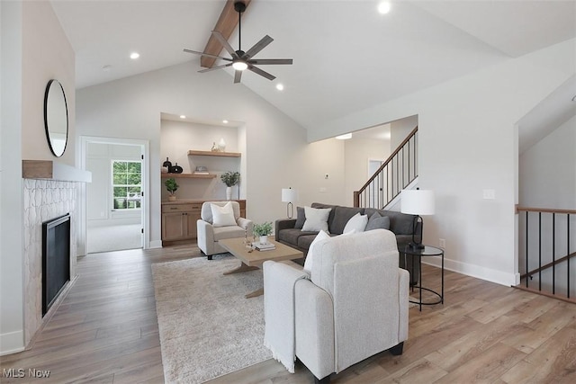 583 Iris Pl, Aurora, OH 44202 - living room featuring a ceiling fan, light wood-style floors, stairway, beam ceiling, and a fireplace