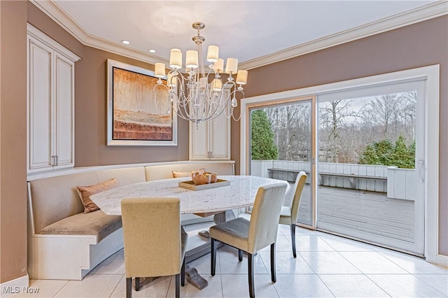 dining space with light tile patterned floors, breakfast area, an inviting chandelier, and ornamental molding