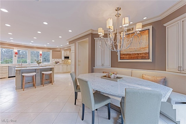 dining space with a chandelier, light tile patterned floors, breakfast area, and ornamental molding