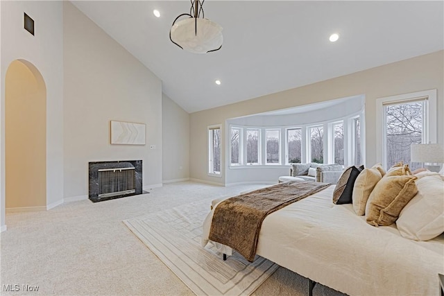 bedroom with high vaulted ceiling and light colored carpet