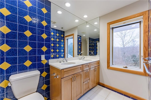 bathroom featuring tile patterned floors, vanity, toilet, and tile walls