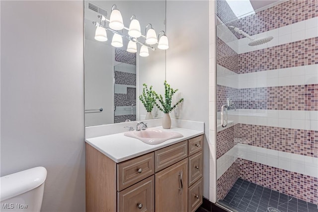 bathroom featuring vanity, toilet, and a shower with door