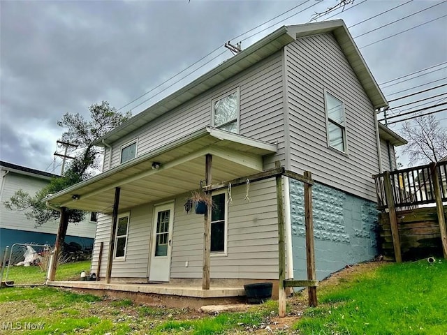 rear view of property featuring a porch