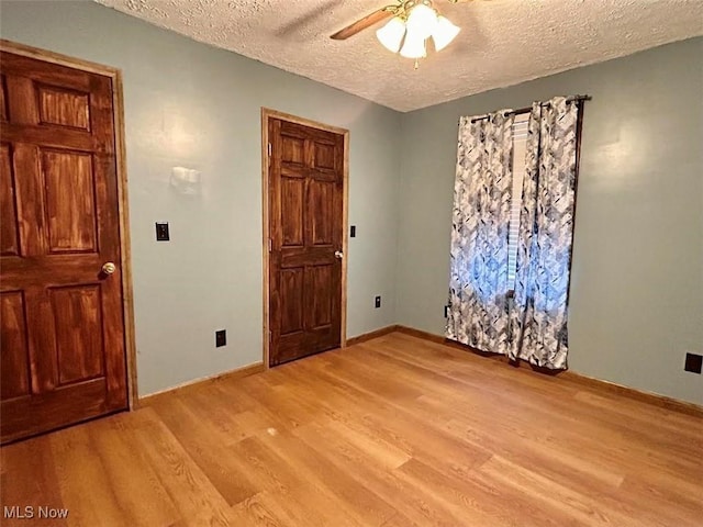 interior space with ceiling fan, light hardwood / wood-style floors, and a textured ceiling