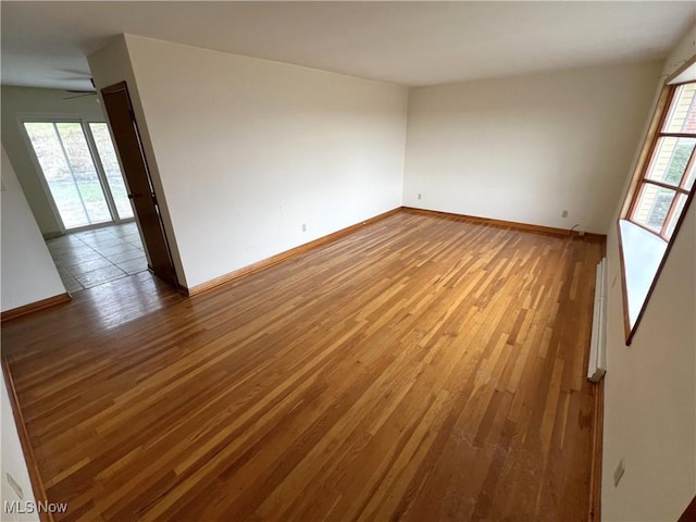 empty room featuring a healthy amount of sunlight and hardwood / wood-style flooring