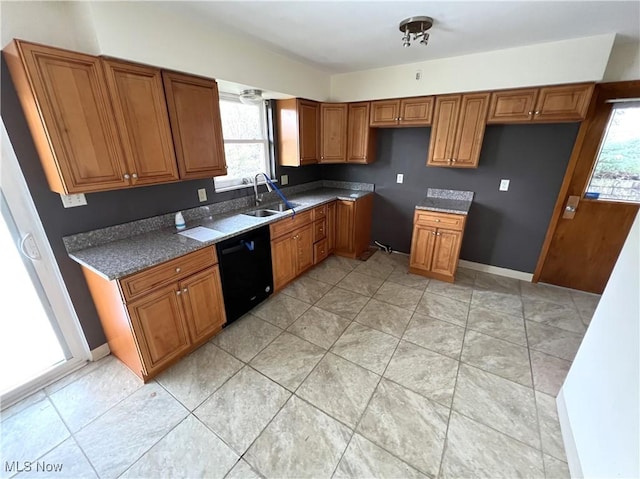 kitchen featuring black dishwasher, a wealth of natural light, dark stone countertops, and sink