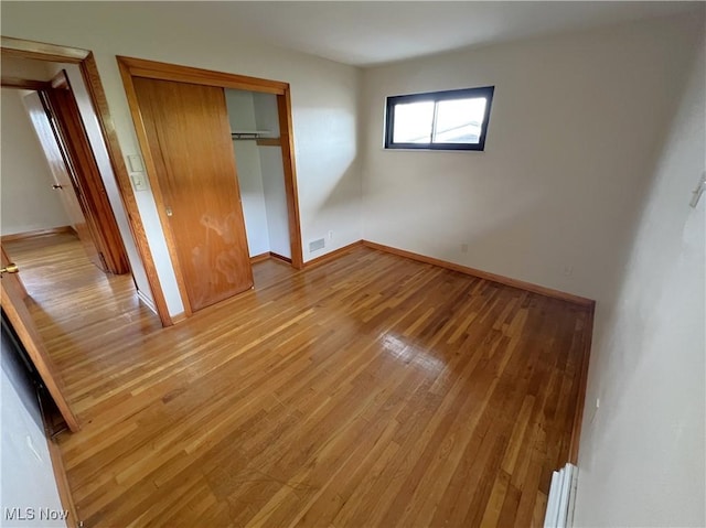 unfurnished bedroom featuring light hardwood / wood-style floors and a closet