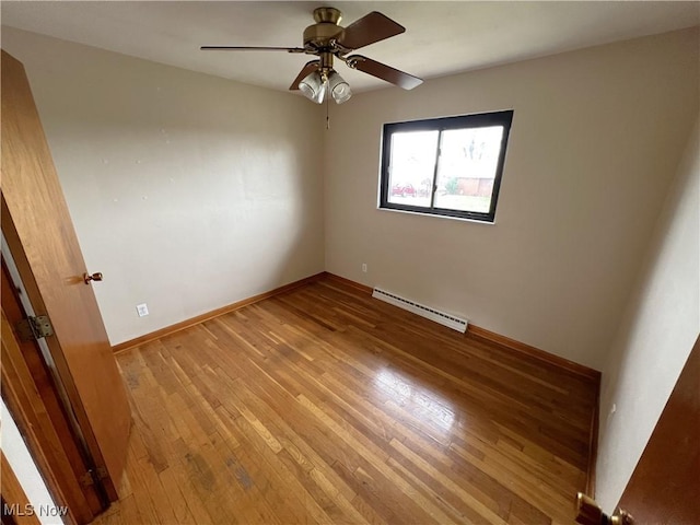 empty room featuring ceiling fan, light hardwood / wood-style flooring, and a baseboard heating unit