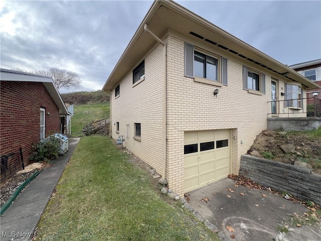 view of side of property featuring a garage and a lawn