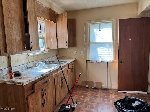 kitchen featuring decorative backsplash, dark parquet flooring, and sink