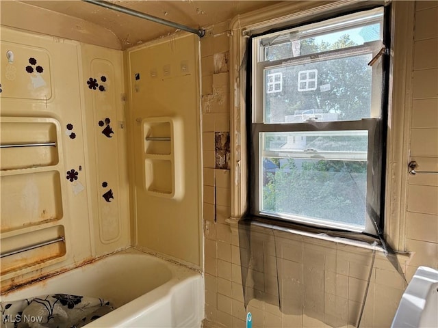 bathroom featuring bathing tub / shower combination and a wealth of natural light