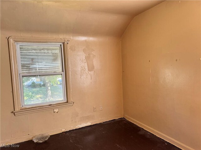 empty room featuring vaulted ceiling