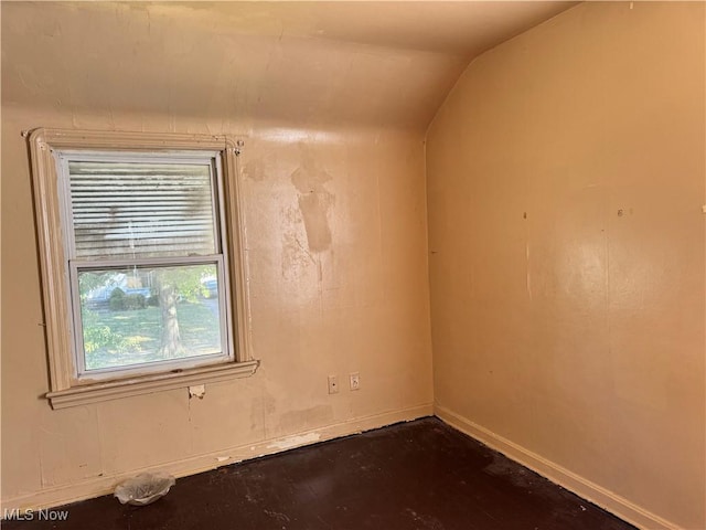 unfurnished room featuring lofted ceiling