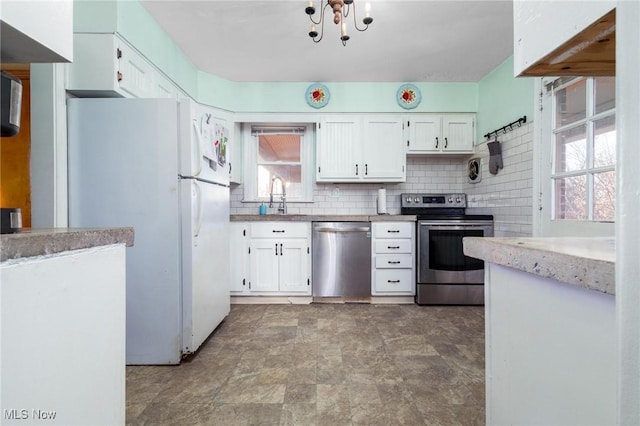 kitchen featuring white cabinets, appliances with stainless steel finishes, a healthy amount of sunlight, and sink