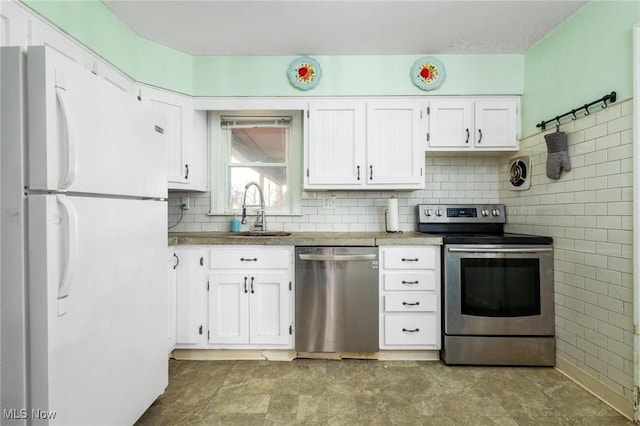 kitchen featuring white cabinets, backsplash, sink, and appliances with stainless steel finishes