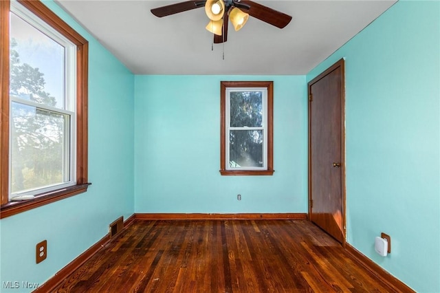 spare room with dark hardwood / wood-style flooring and ceiling fan