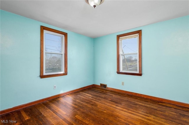 unfurnished room with dark wood-type flooring