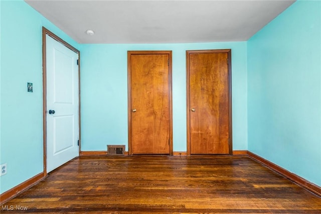 unfurnished bedroom featuring dark wood-type flooring