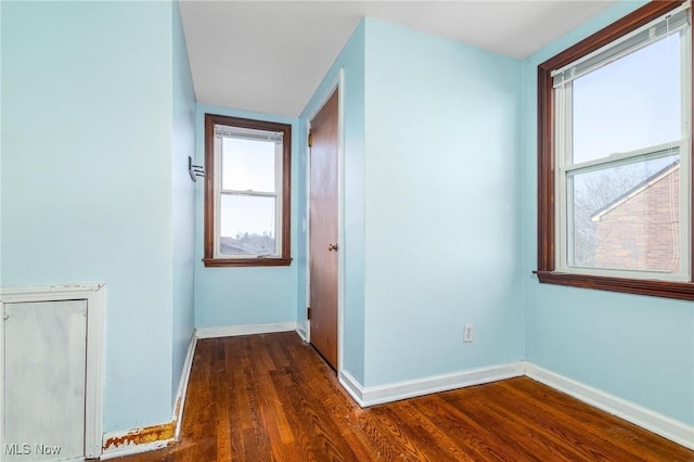 hall featuring a wealth of natural light and dark hardwood / wood-style floors