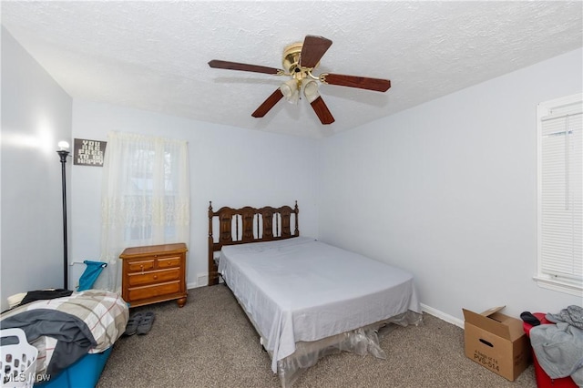 carpeted bedroom with ceiling fan and a textured ceiling