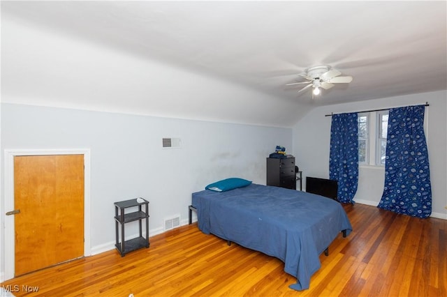 bedroom with hardwood / wood-style flooring, vaulted ceiling, and ceiling fan