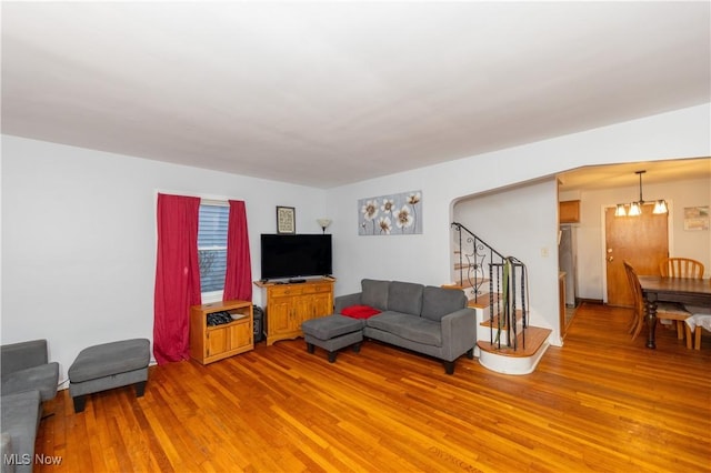 living room with hardwood / wood-style floors and a notable chandelier